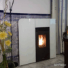 Salamandra a Pellets Canalizável Biobronpi Cleo instalada em uma cozinha moderna, aquecendo o ambiente.