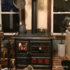 Fogão a Lenha em Ferro Fundido - Nordica Extraflame Rosa XXL em cozinha rústica, criando um ambiente acolhedor e quente.