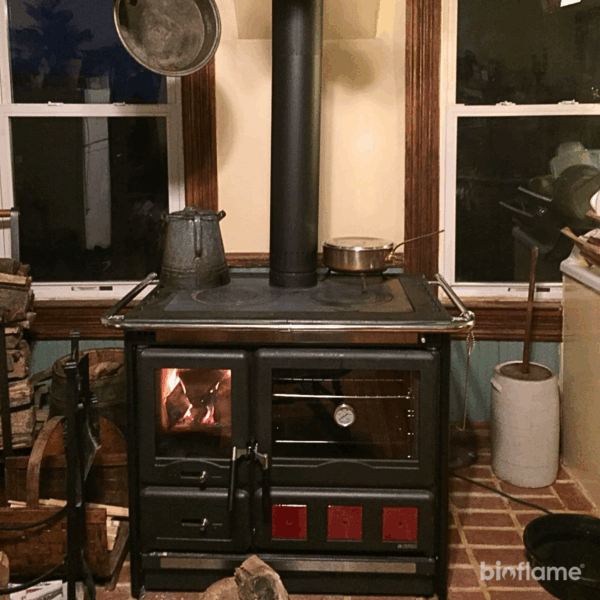 Fogão a Lenha em Ferro Fundido - Nordica Extraflame Rosa XXL em cozinha rústica, criando um ambiente acolhedor e quente.